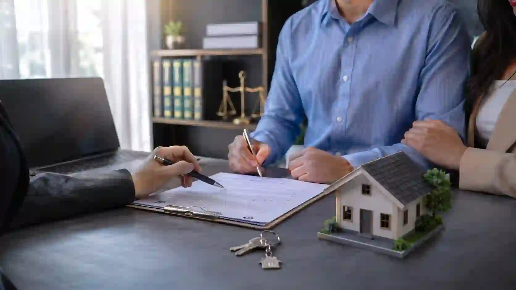 Conveyancing — a property lawyer and clients reviewing documents with a house key