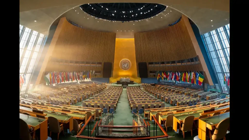 United Nations General Assembly hall with rows of desks and member state flags