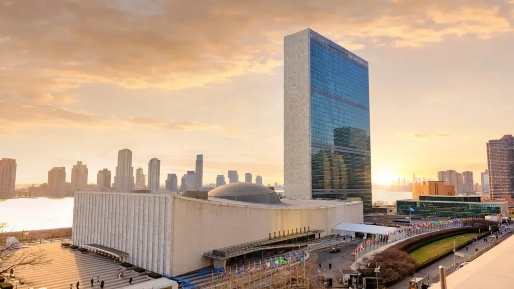 UN headquarters in New York at golden hour with flags of member nations